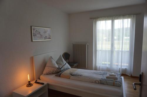 a small bedroom with a bed and a candle on a table at good bed wynau in Wynau