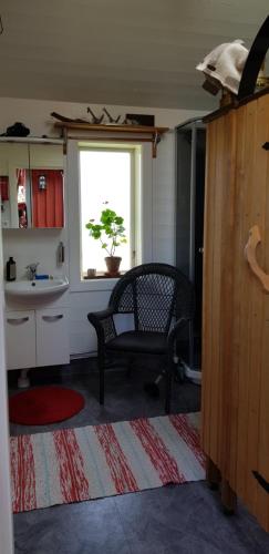 een woonkamer met een stoel en een raam bij Hamburgö, Hasselbacken 2 in Hamburgsund