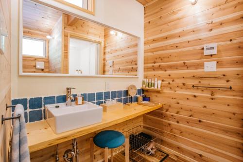 een badkamer met een wastafel en een spiegel bij PACIFICO SURF HOUSE - Mountain in Shishikui