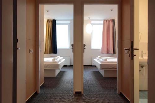 a room with two beds and two windows at Maverick Budapest Soho in Budapest