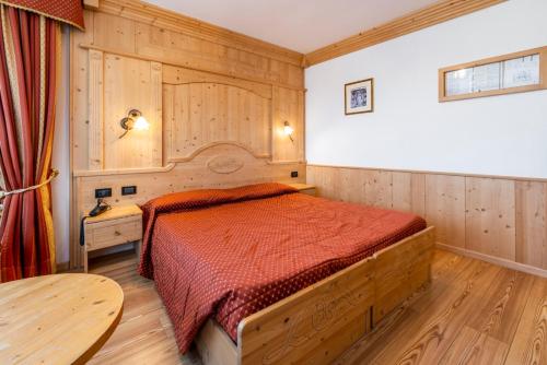 sypialnia z łóżkiem z czerwoną narzutą w obiekcie LM Rooms w mieście Fondo