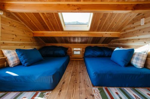 two blue couches in the living room of a tiny house at PACIFICO SURF HOUSE - Mountain in Shishikui
