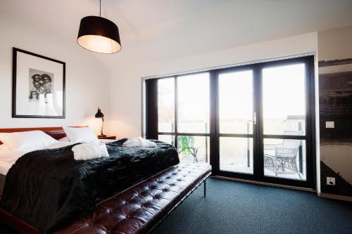 a bedroom with a bed and a large window at Hotell Mossbylund in Abbekås