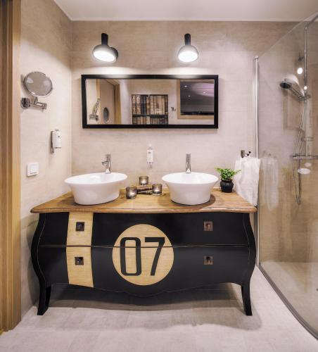 a bathroom with two sinks and a shower at Hotell Mossbylund in Abbekås