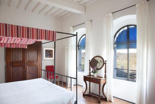 sypialnia z łóżkiem, lustrem i oknem w obiekcie Agriturismo Borgo Personatina w mieście Sovicille