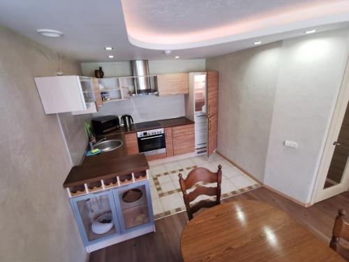 a small kitchen with a table and a stove at Pušynas Apartments in Juodkrantė