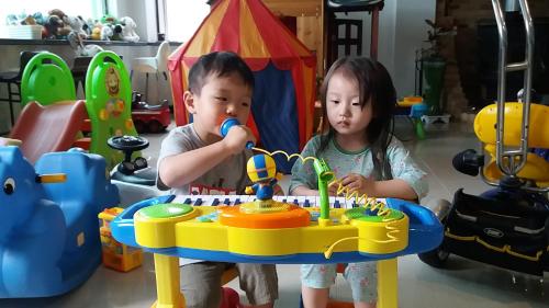 a boy and a girl blowing out candles on a birthday cake at Forest of Color Pension in Hongcheon