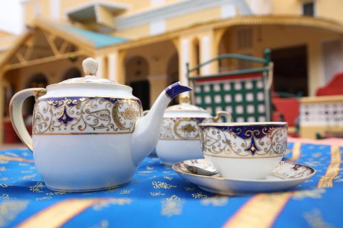 three tea cups and a teapot on a table at Roop Niwas Kothi, Near Mandawa in Nawalgarh