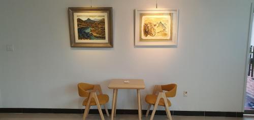 a table and two chairs against a white wall at Forest of Color Pension in Hongcheon