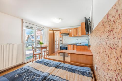 a kitchen with a bed and a table in a room at Fortun Estate - apartmaji ob reki Kolpi in Metlika