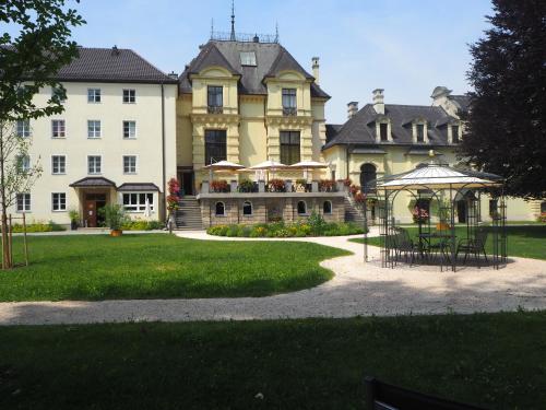 una casa grande con una mesa y sillas delante de ella en Johannes Schlössl - Gästehaus der Pallottiner am Mönchsberg en Salzburgo