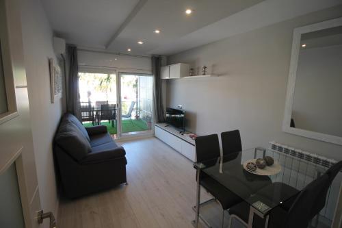 uma sala de estar com um sofá e uma mesa de jantar em Family Deluxe Apartment Beach em Castelldefels