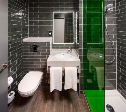 a bathroom with a sink and a toilet and a mirror at ibis Styles London Ealing in Ealing