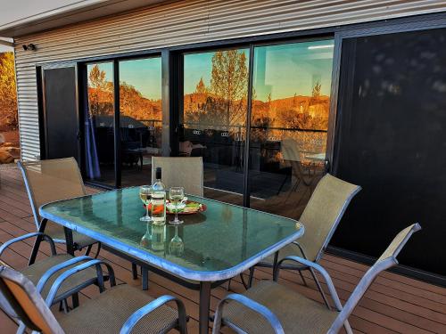 a table on a balcony with glasses of wine at Skytrek Willow Springs Station in Flinders Ranges