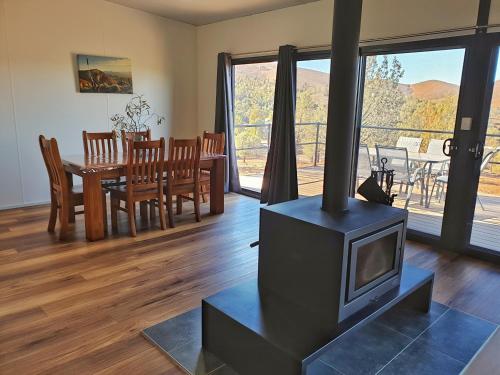 a living room with a fireplace and a dining room at Skytrek Willow Springs Station in Flinders Ranges