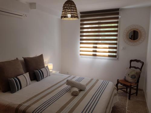 1 dormitorio con cama, ventana y silla en VILLA REVA APPARTEMENT, en Les Issambres