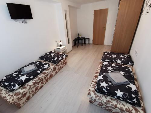 a room with two beds and a flat screen tv at Penzión Bernáth in Rožňava