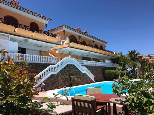 a villa with a swimming pool and a house at Chalets Rurales Bentayga in Tejeda