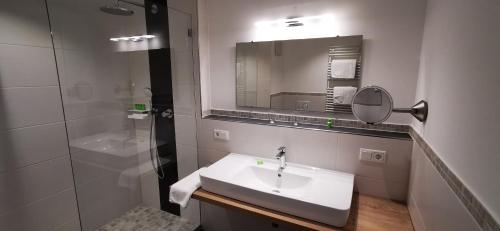 a bathroom with a sink and a shower and a mirror at Ferienhaus Wetterstein in Grainau