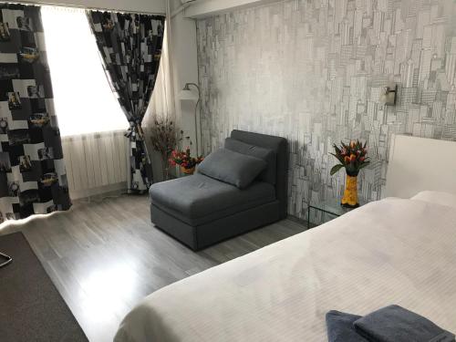 a bedroom with a bed and a couch and a window at Universitate Residence in Bucharest