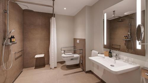 a bathroom with a toilet and a sink and a shower at Die Sandburg in Langeoog