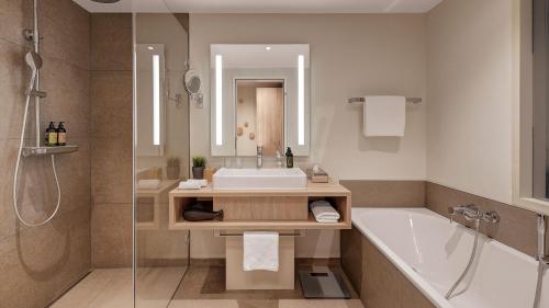 ein Badezimmer mit einer Badewanne, einem Waschbecken und einer Badewanne in der Unterkunft Die Sandburg in Langeoog