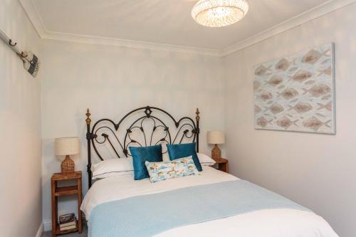 a bedroom with a large bed with blue pillows at Beach Cottage in Lytham St Annes