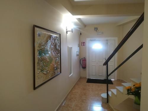 a hallway with a painting on the wall and a staircase at Hostal El Rincón - Casa Marcos in Yepes