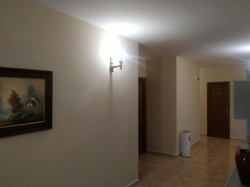 um quarto com uma luz numa parede com uma fotografia em Hostal El Rincón - Casa Marcos em Yepes