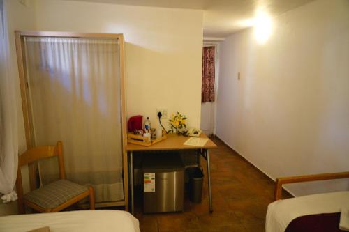 a room with a table and a chair and a desk at Hotel Uhland in Windhoek