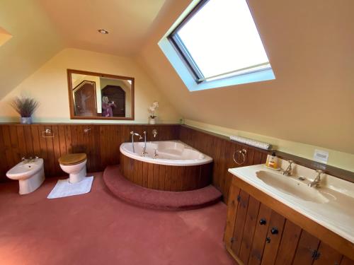 a bathroom with a tub and a toilet and a sink at Stunning Rustic Home, New Forest National Park in Southampton