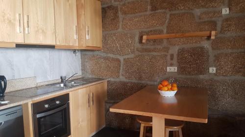 a kitchen with a table with a bowl of oranges on it at Olhares do Douro "A casa do Avô Zé" in Torre de Moncorvo