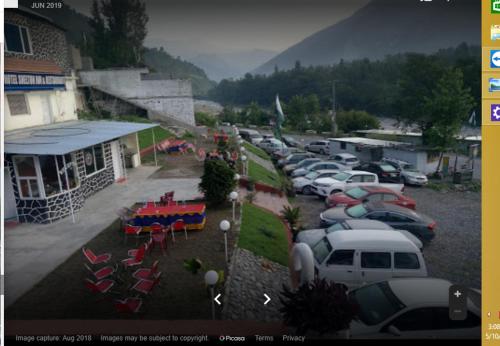 a parking lot with a bunch of parked cars at Hotel Shelton Inn in Batkarar