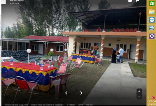 a group of tables and chairs in front of a building at Hotel Shelton Inn in Batkarar