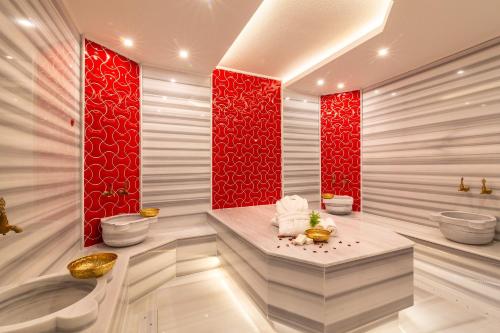 カルカンにあるLa Mer Deluxeのトイレが2つあり、壁が赤いバスルーム