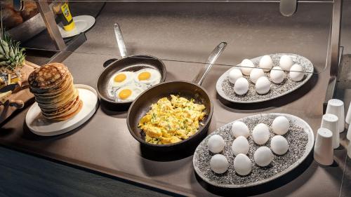 a counter top with eggs and breakfast foods on plates at Die Sandburg in Langeoog