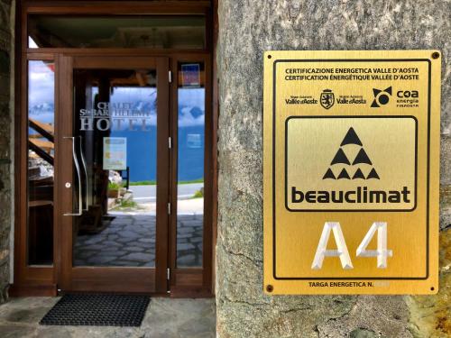 a sign in front of a door of a building at Chalet Saint-Barthélemy Hotel in Nus