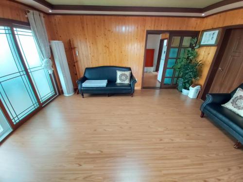 a living room with a couch and a chair at Feeling Good House in Jeju