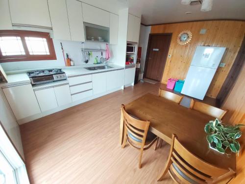a kitchen and dining room with a wooden table at Feeling Good House in Jeju