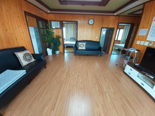 a living room with a couch and a tv at Feeling Good House in Jeju