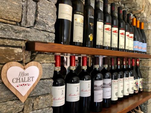 a bunch of wine bottles lined up on a wall at Chalet Saint-Barthélemy Hotel in Nus