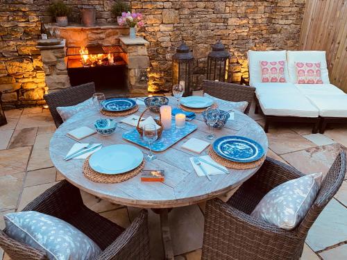 uma mesa de madeira com placas azuis e brancas em Campden Mews em Chipping Campden