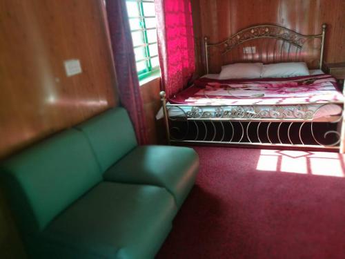 een woonkamer met een bank en een bed bij Nathia Heights Hotel in Bāzār