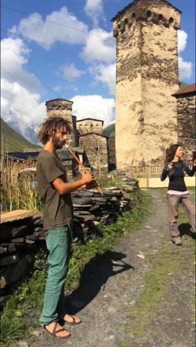 a man playing a violin in front of a castle at Nizharadze's Tower in Ushguli