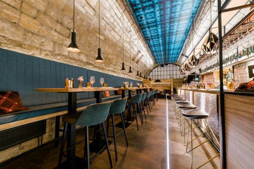 un bar avec une rangée de tabourets de bar dans l'établissement Weinhotel Freylich Zahn, à Freyburg