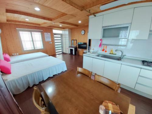 済州市にあるFeeling Good Houseのベッドとキッチン付きの広い客室です。
