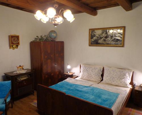 1 dormitorio con 1 cama y una pintura en la pared en Nevšední ubytování jako u babičky ve stylu 60.let, en Budkovce