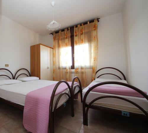 a bedroom with two beds and a window at Villa Gloria appartamento E01 in Rosolina Mare