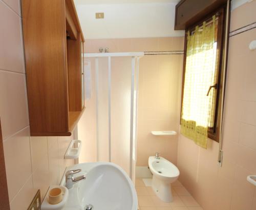 a bathroom with a white sink and a toilet at Villa Gloria appartamento E01 in Rosolina Mare