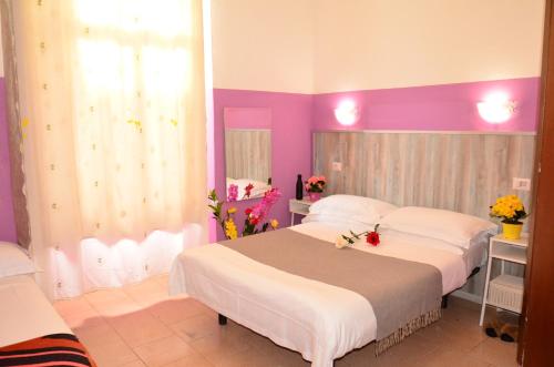 1 dormitorio con 2 camas y paredes rosas y moradas en Hotel New Milan en Milán